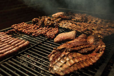 Close-up of meat on barbecue grill at night