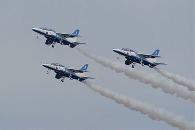 Low angle view of airshow against sky