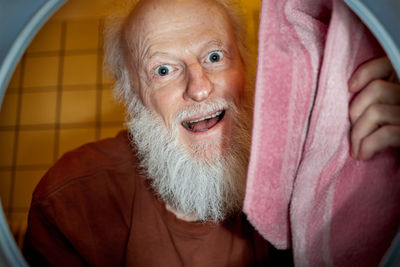 Portrait of smiling man seen through washing machine