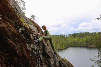 A woman engaged in rock climbing on the rocks of hawk lake