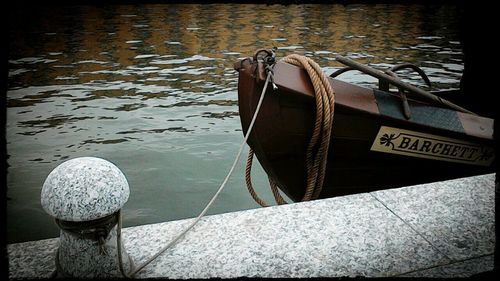 Close-up of boat moored in lake