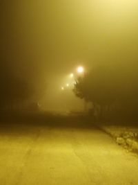 Snow covered street against sky at night