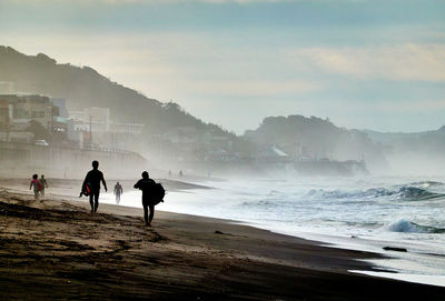 People on beach against sky