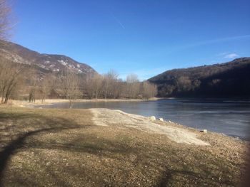 Scenic view of lake against clear blue sky