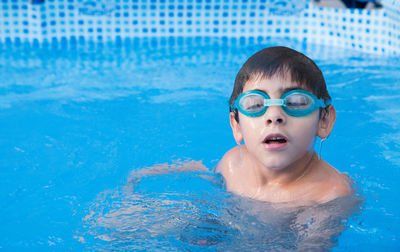 Portrait of shirtless boy swimming in pool