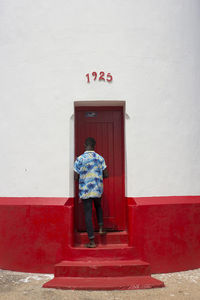 Rear view of man standing against door