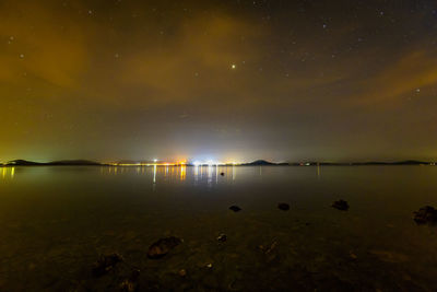 Scenic view of lake against sky at night