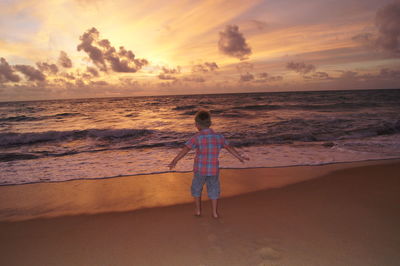 Rear view of boy standing on beach