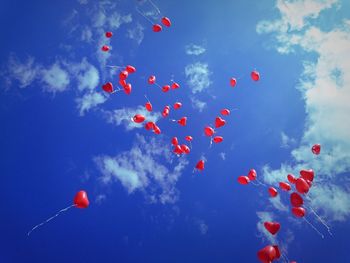 Low angle view of kites against blue sky