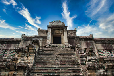 Low angle view of old temple against cloudy sky