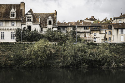 Buildings in lake against sky