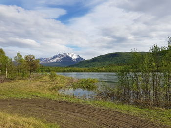 Scenic view of lake by mountains against sky