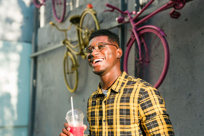 Portrait of young man blowing bubbles against wall