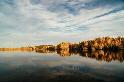 Scenic view of lake by trees against sky