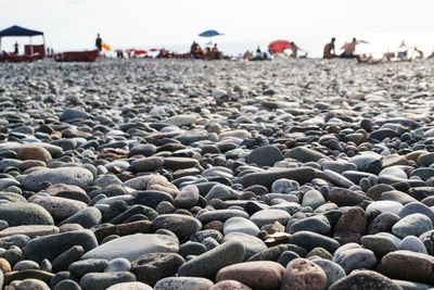 Close-up of pebbles on beach against sky