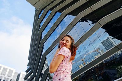 Low angle view of woman standing against sky