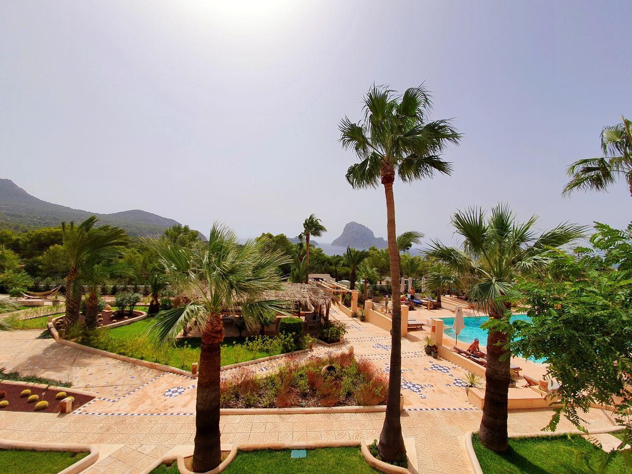 PALM TREES ON SWIMMING POOL AGAINST SKY