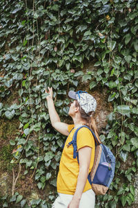 Side view of woman standing amidst plants