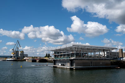 Panoramic view of harbor by buildings against sky