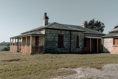 Exterior of old house on field against clear sky