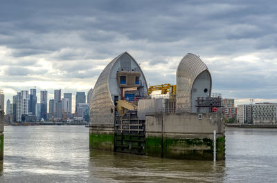 Buildings in city against cloudy sky