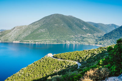 Scenic view of lake and mountains against blue sky