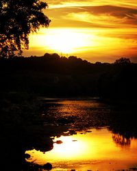 Scenic view of lake against orange sky