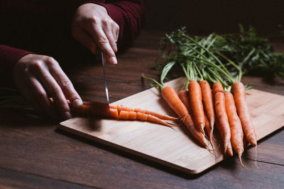 Midsection of person preparing food on cutting board