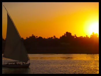 Boat sailing in sea at sunset