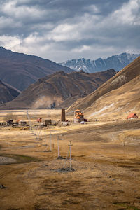 Scenic view of field and mountains against sky