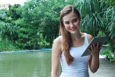 Portrait of smiling young woman in swimming pool