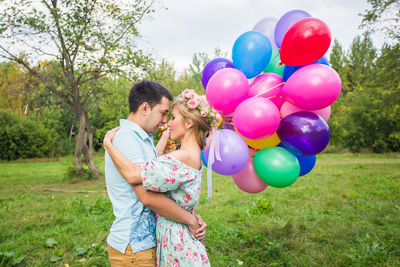 Young couple holding balloons