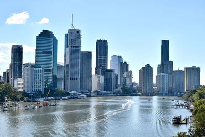 Sea by buildings against sky in city