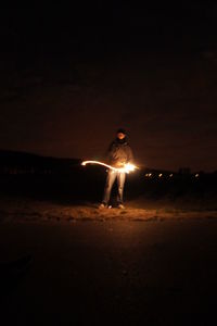 Woman standing on beach at night