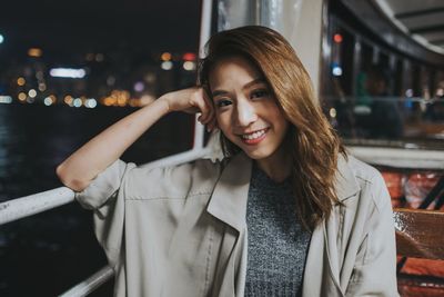 Portrait of smiling woman in city at night