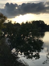 Scenic view of river against sky at sunset