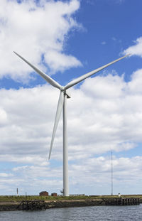 Wind turbine against cloudy sky