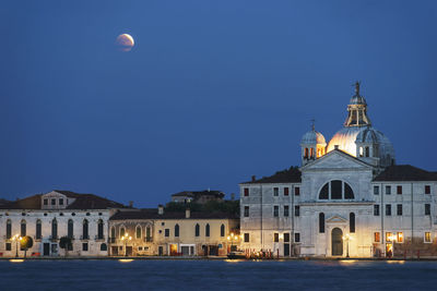 Buildings against blue sky at night