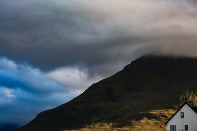 Low angle view of buildings against cloudy sky