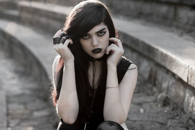 Portrait of beautiful young woman standing against blurred background
