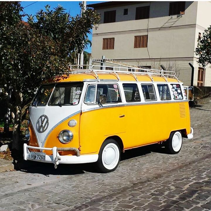 YELLOW VINTAGE CAR ON STREET IN CITY