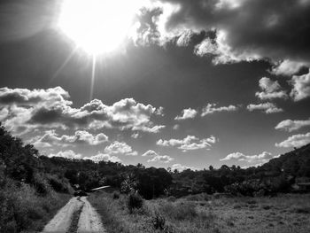 Road amidst trees against sky