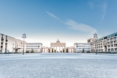 Street by brandenburg gate against sky