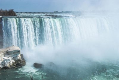 Scenic view of waterfall against sky