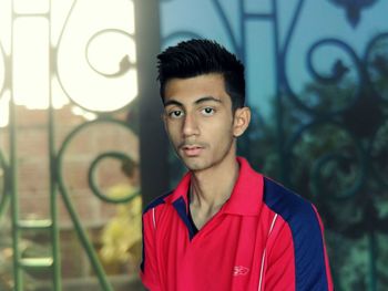 Portrait of young man against gate