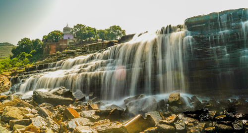 Scenic view of waterfall against sky