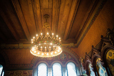 Low angle view of illuminated light bulbs hanging from ceiling