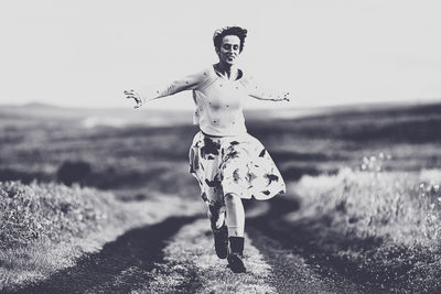 Portrait of young woman standing on field