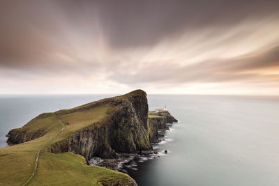 Scenic view of sea against cloudy sky during sunset