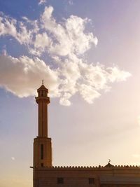 Low angle view of cross on building against sky